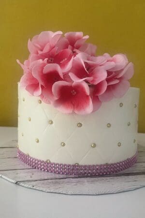 White with pink roses and purple trimmings wedding Cake